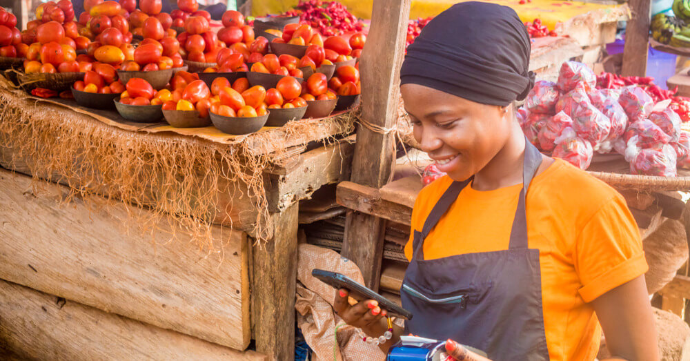 A young woman sells tomatoes