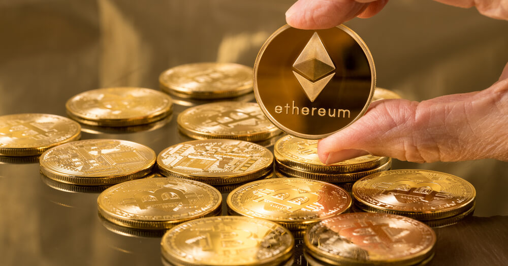 Image of Ethereum coin being held over bitcoins