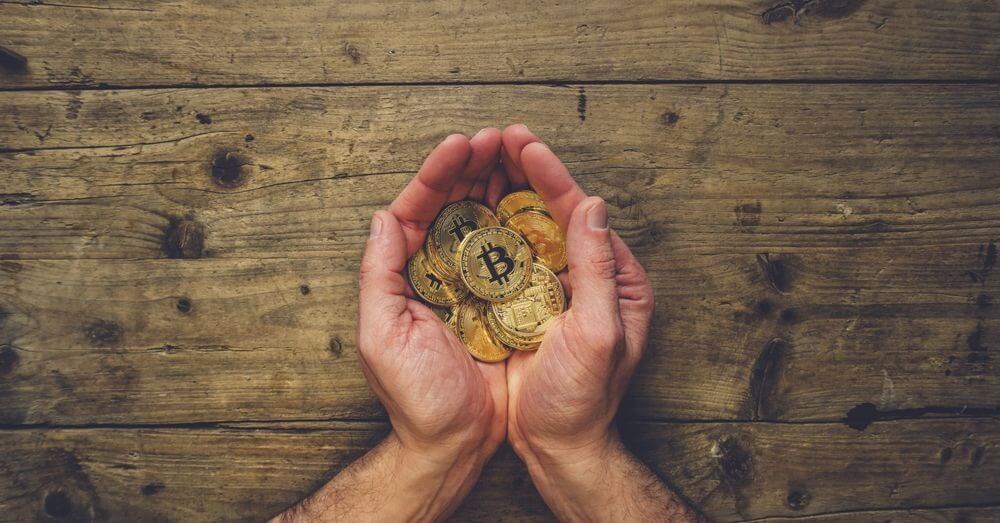 Image of hands holding pile of bitcoins