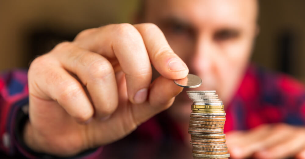 A man counting coins and stacking them