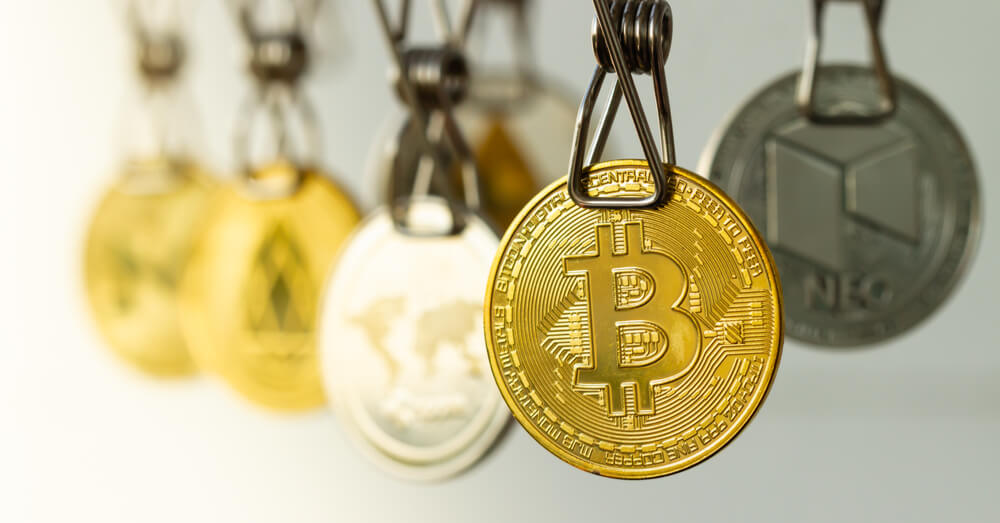 Image of Bitcoin and other cryptos hanging on a rope and held by a clothespin