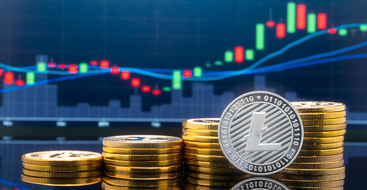 A silver LTC coin in front of rising trading chart