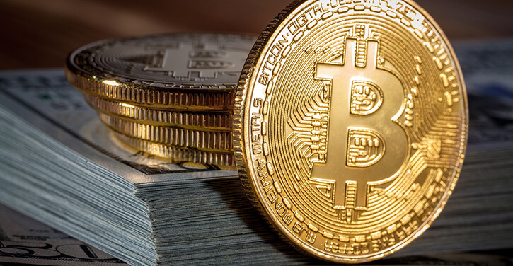 Golden Bitcoin on us dollars close up