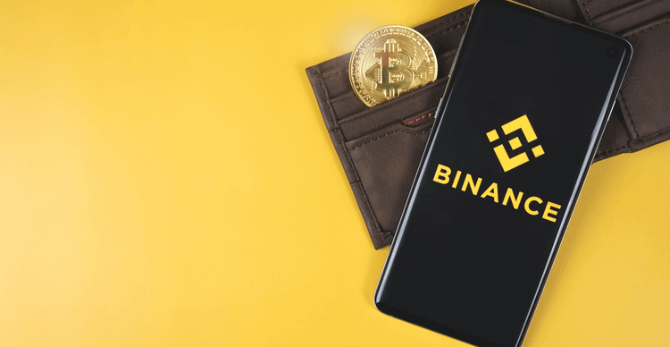 De mobiele Binance app en een portemonnee met een Bitcoin