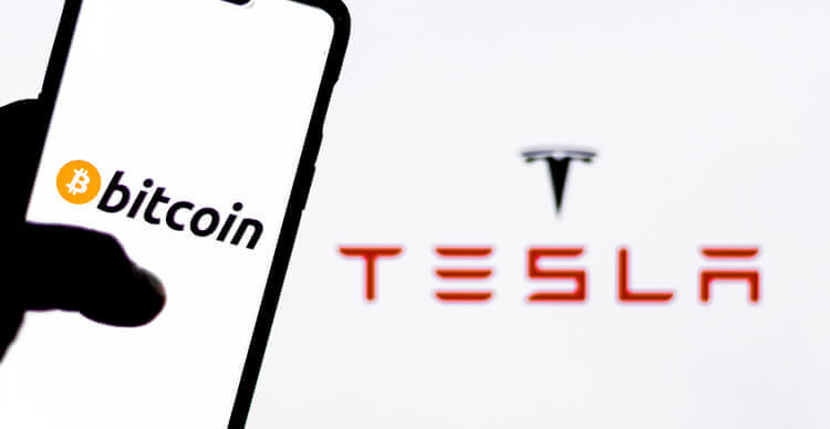 Het Tesla logo en die van Bitcoin op een smartphone