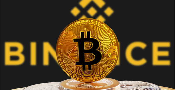 BTC op een stapel cryptomunten met het Binance logo op de achtergrond