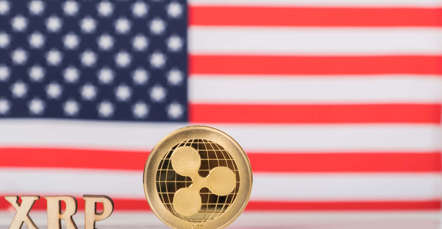 Een Ripple coin met XRP letters met daarachter de Amerikaanse vlag