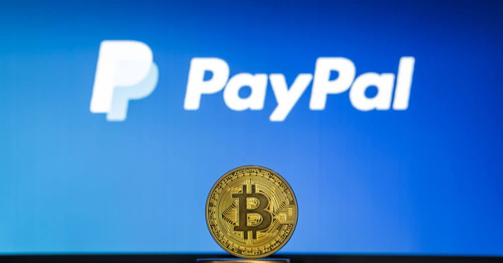 Bitcoin op een stapel munten met daarachter het PayPal logo