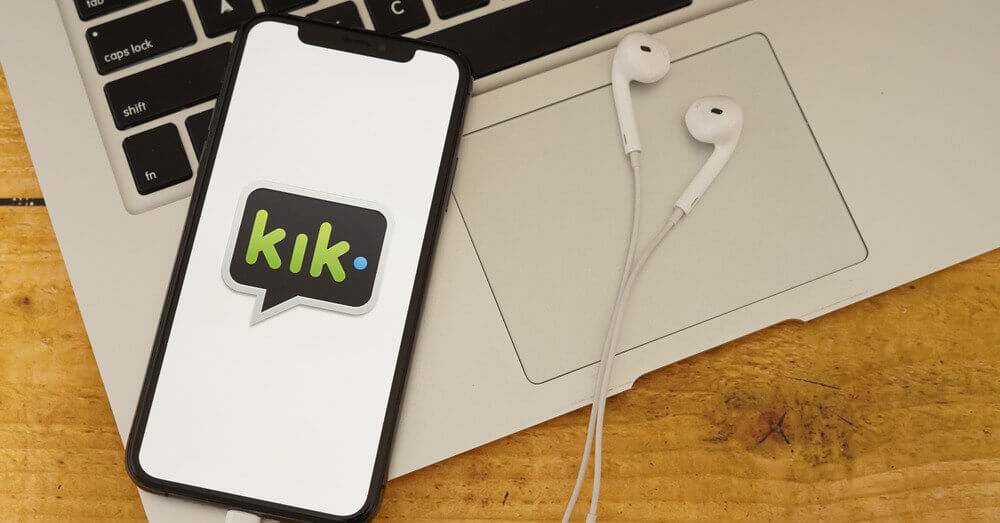 Foto van de Kik messenger app en een laptop