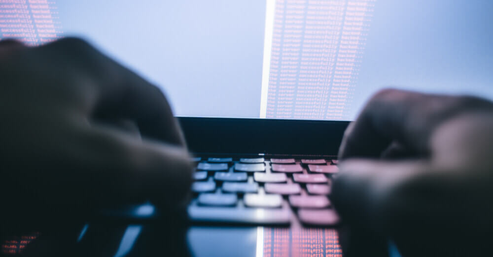 Foto van een hacker die aan malware werkt