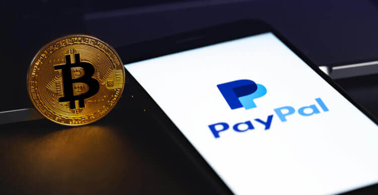 Foto van de PayPal app op een smartphone naast een Bitcoin