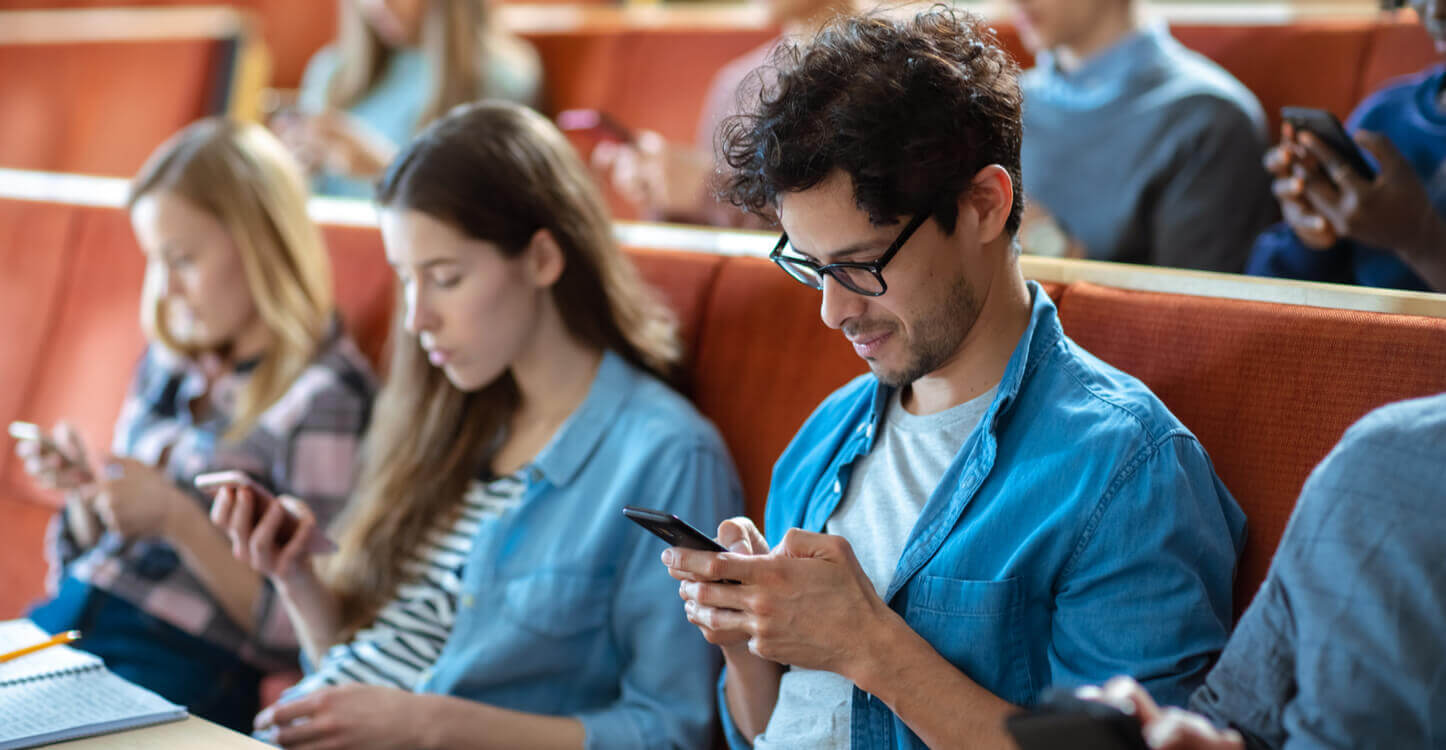 Foto van studenten die mobieltjes gebruiken