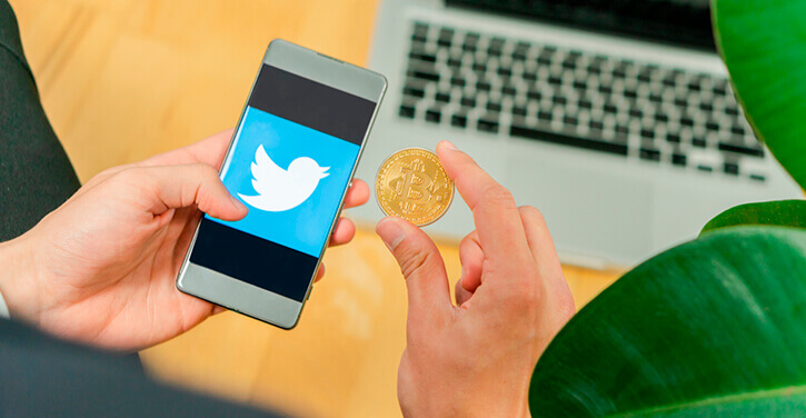 Foto van een Bitcoin voor het Twitter logo op een smartphone