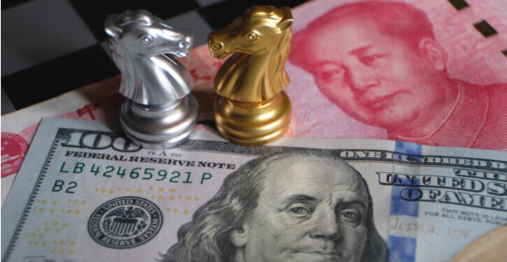 Foto van een Amerikaanse dollar en Chinees yuan bankbiljet met schaakstukken die de recente handelsoorlog voorstellen