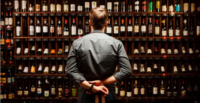 Un Barman dans une cave à vin remplie de bouteilles