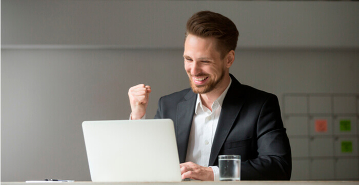 Un homme heureux devant un ordinateur