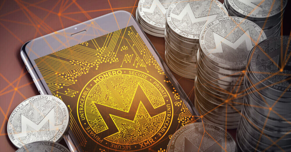 Le logo Monero dans un smartphone parmi une pile de coins