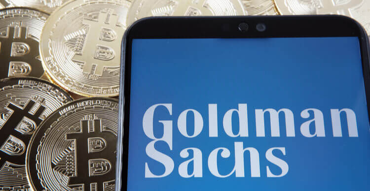 Image du logo de Goldman Sachs sur un smartphone au dessus de Bitcoins