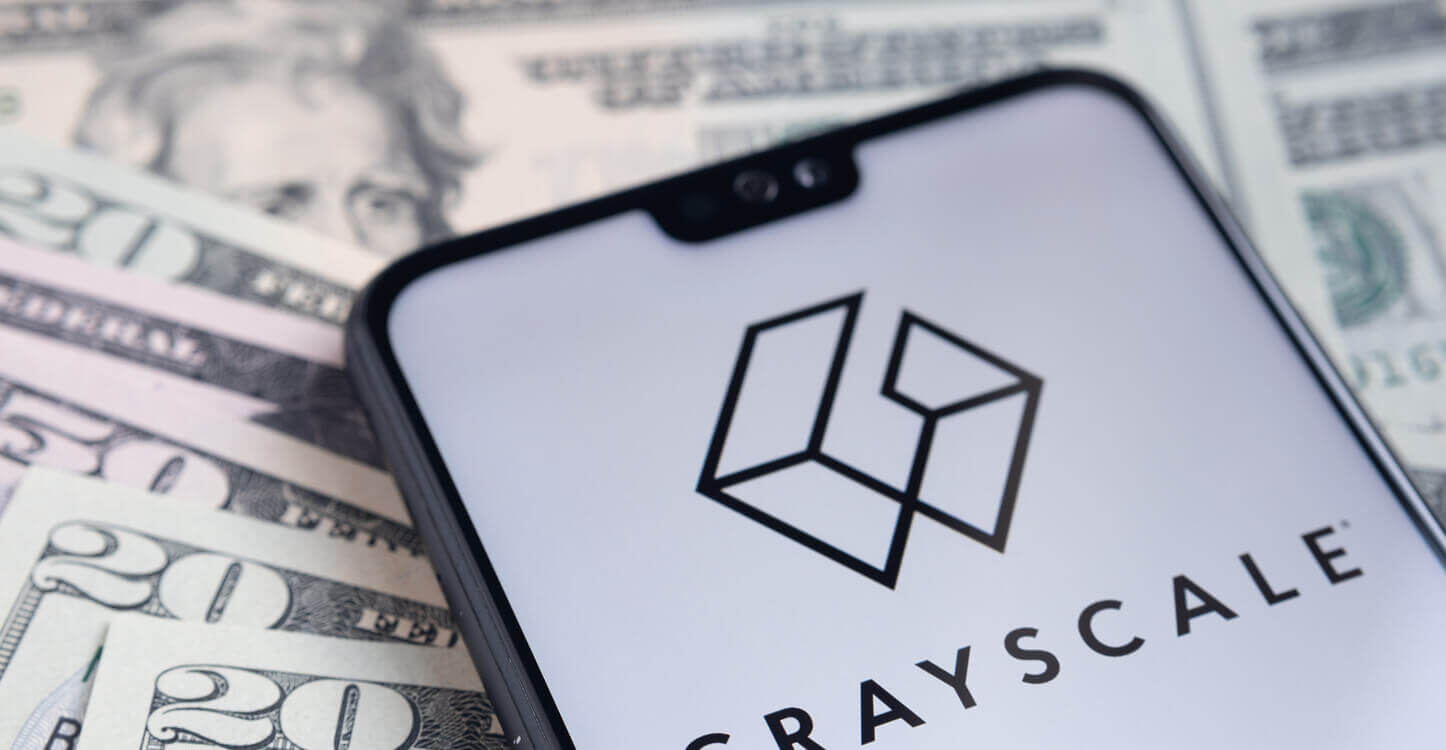 Logo de Grayscale sur un smartphone posé sur des billets de banque