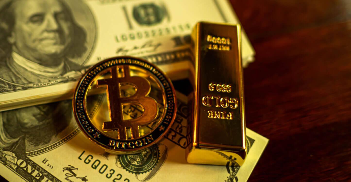 Image d'un bitcoin et d'un lingot d'or sur des billets de banque américains