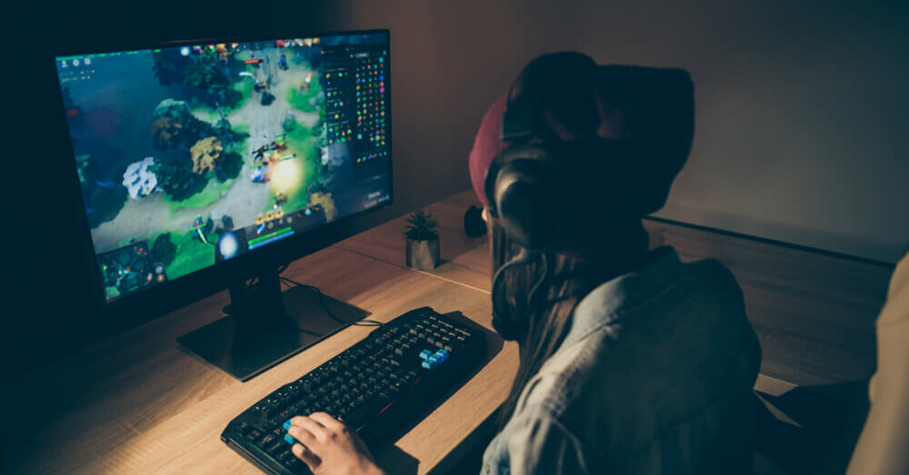 Image d'un joueur assis devant son PC et son clavier