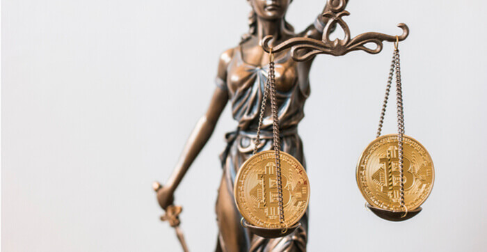 Une image de la statue de la Justice avec des Bitcoins sur ses plateaux