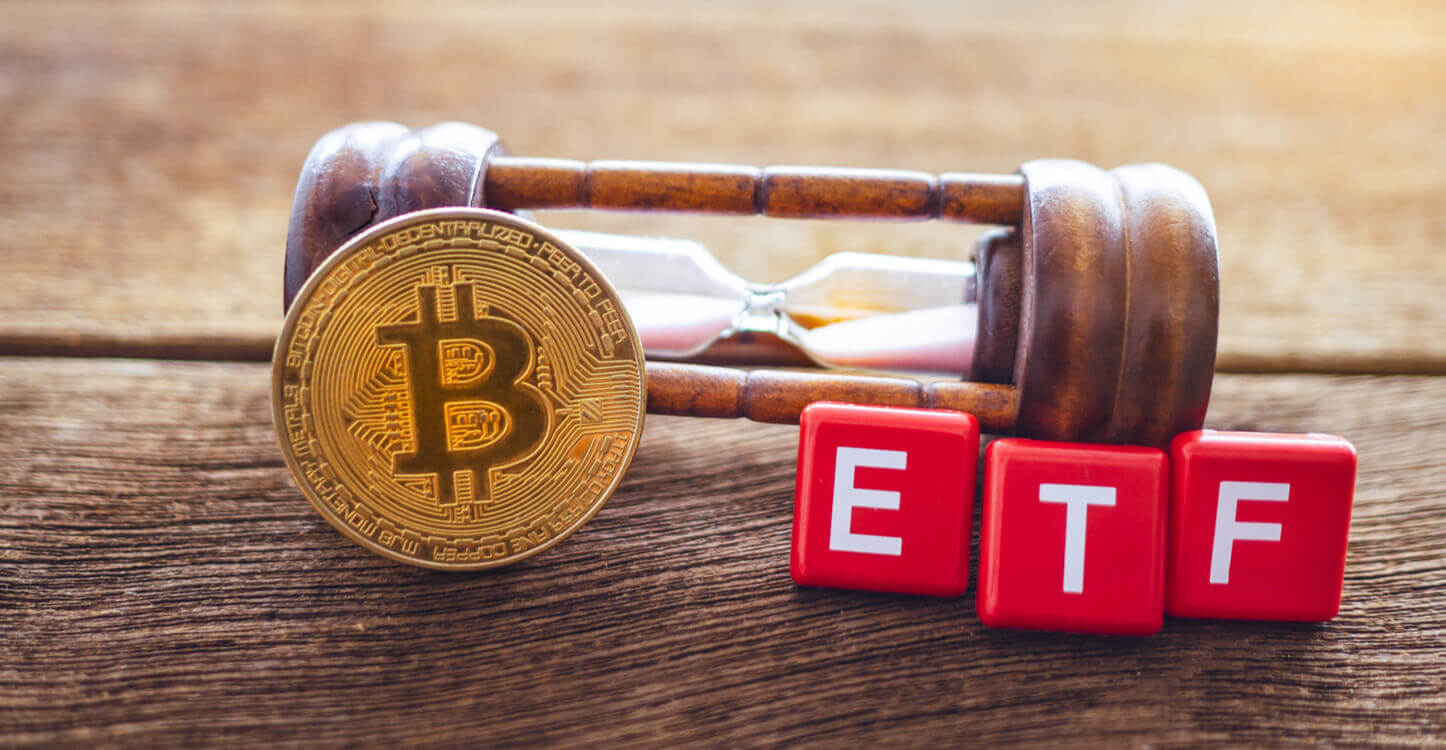 L'image d'un Bitcoin et de jetons portant l'inscription ETF et reposant sur un sablier