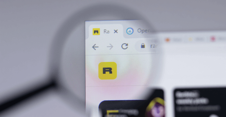 Une loupe permet d'obtenir un gros plan du site web de Rarible, avec un arrière-plan flou