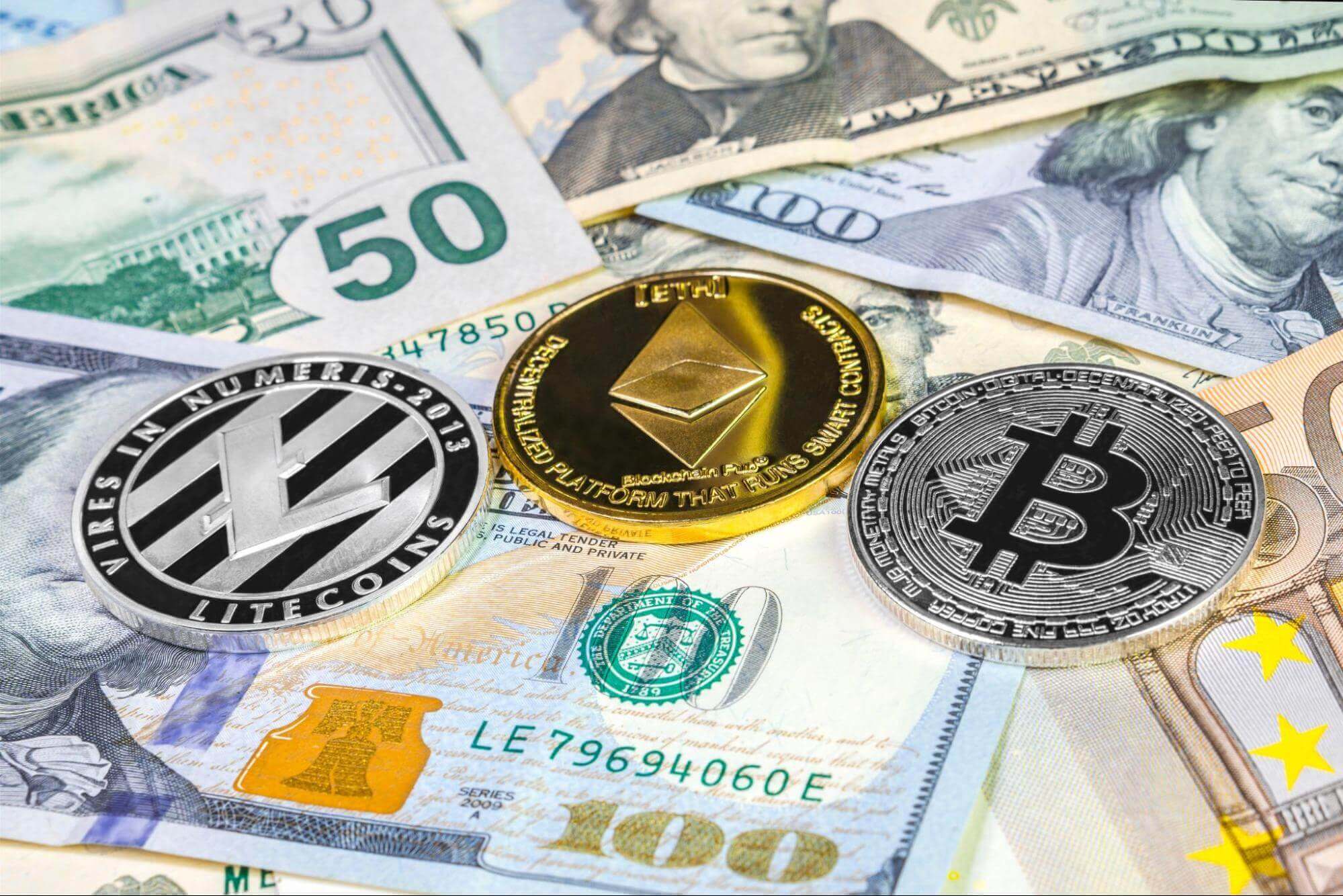 Un seul Bitcoin, Ethereum et Litecoin physique au-dessus de plusieurs billets de banque