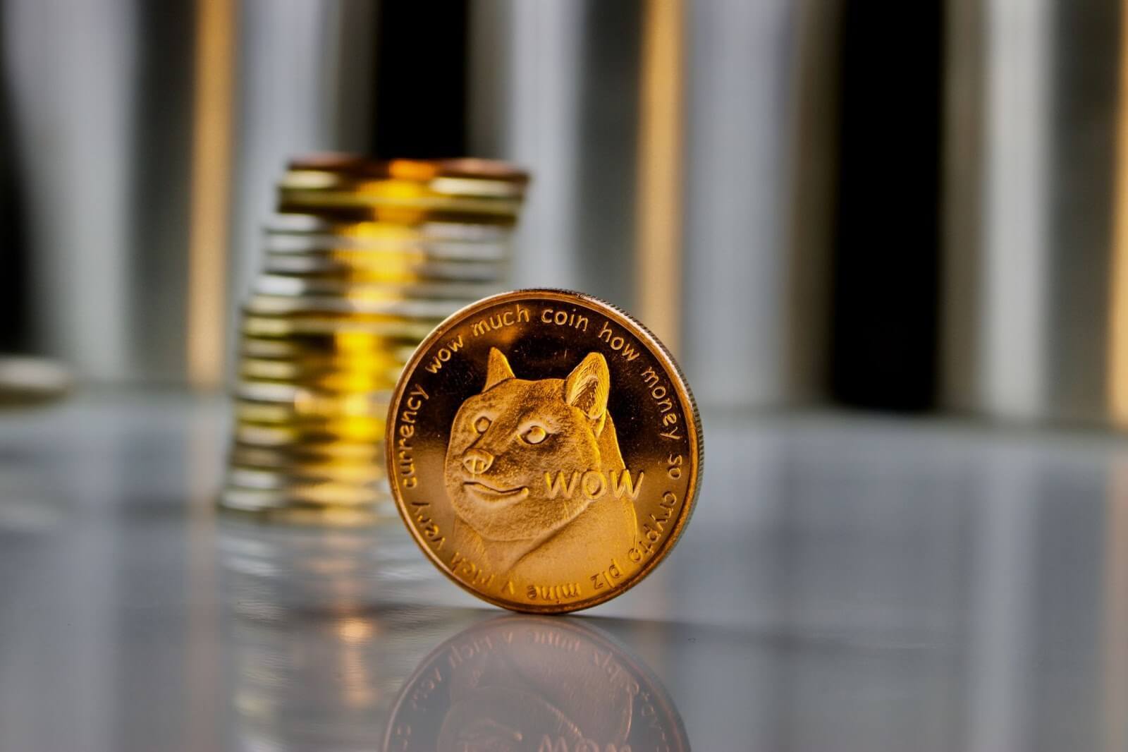 Un jeton Dogecoin en métal sur le côté devant une simple pile de pièces. 