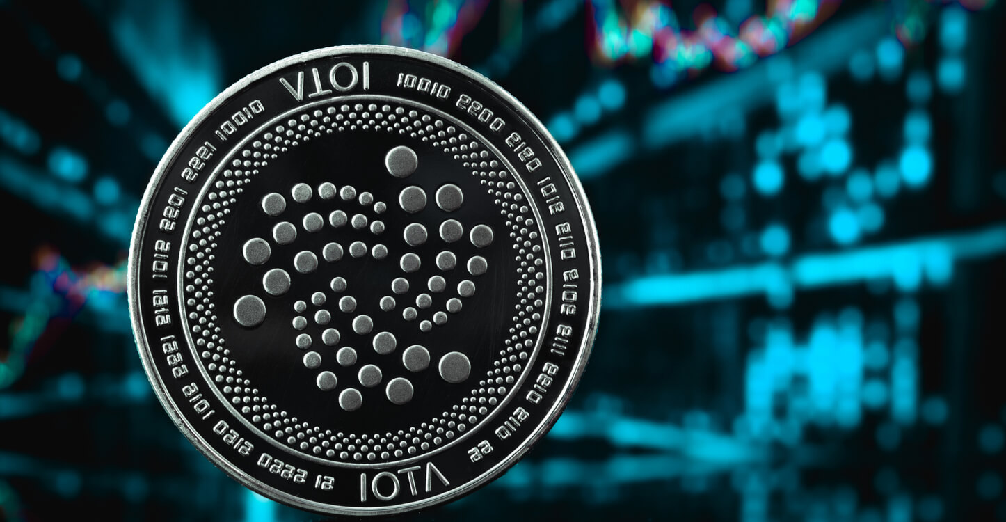 Ein Bild der IOTA-Münze mit Handelsgrafik im Hintergrund