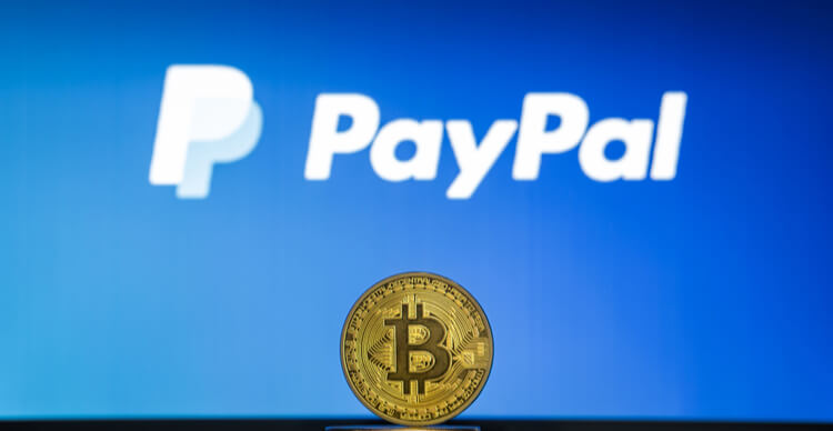 Bitcoin auf einem Stapel Münzen mit dem PayPal-Logo auf einem Laptop-Bildschirm