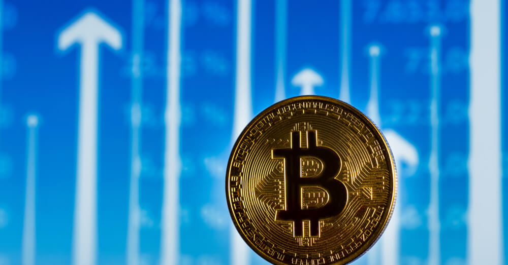 Bild eines Bitcoins vor einem Kartenhintergrund mit nach oben zeigenden Pfeilen