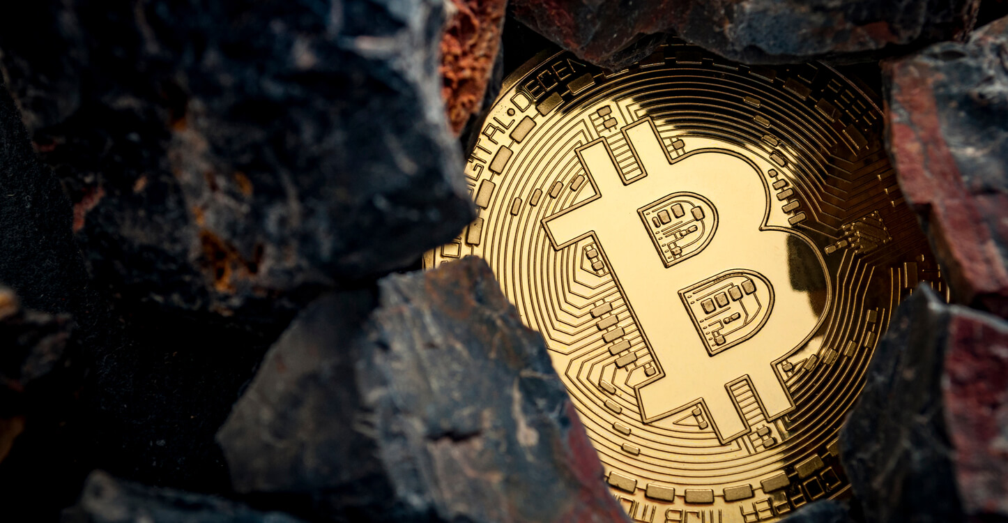 Bild eines Bitcoins unter Felsen