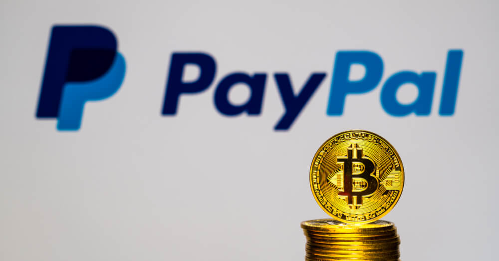 Ein Bild gestapelter Bitcoins vor dem PayPal-Logo