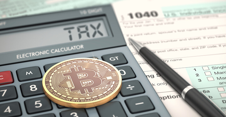 Bitcoin on a calculator and tax sheet