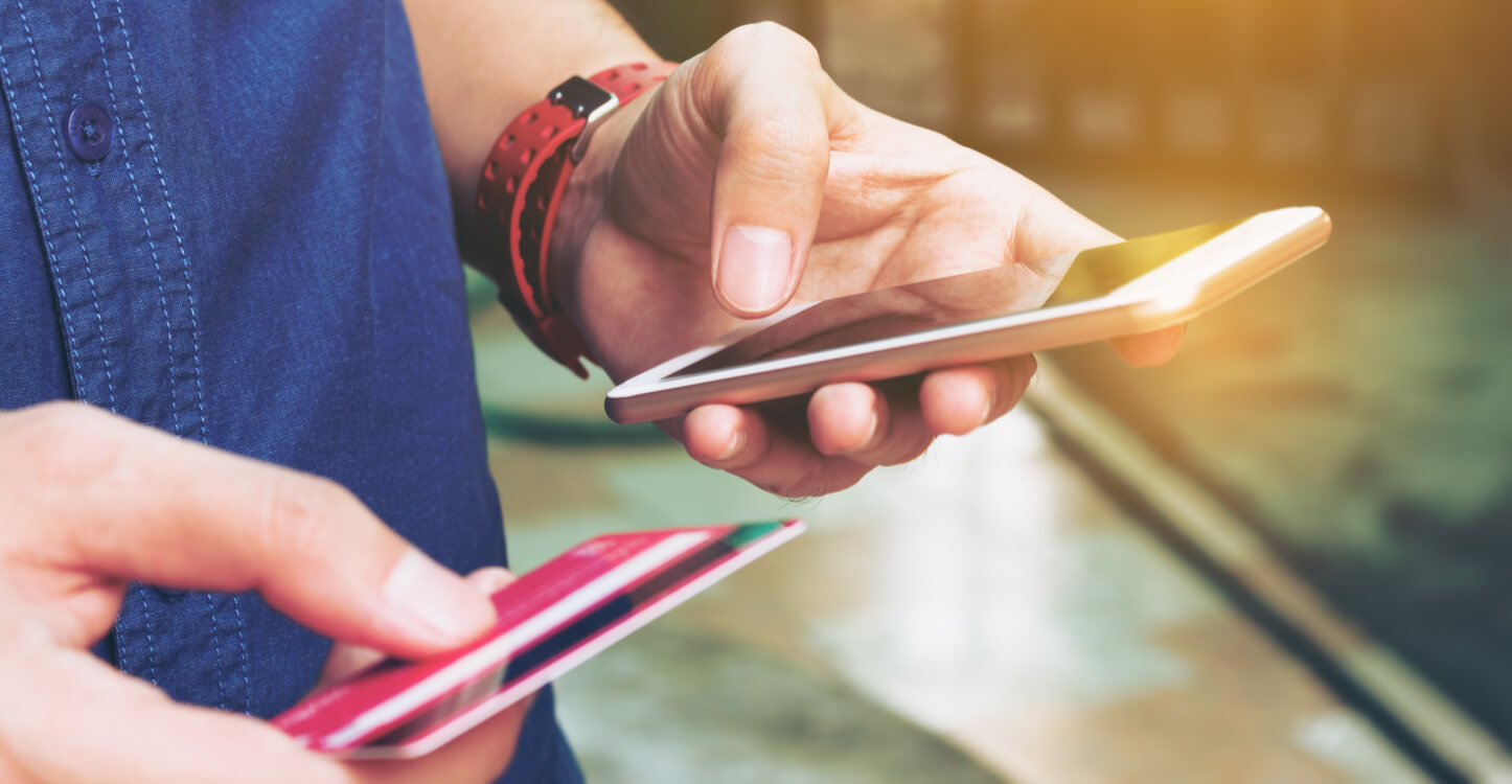 Image of a man entering credit card details on a mobile device