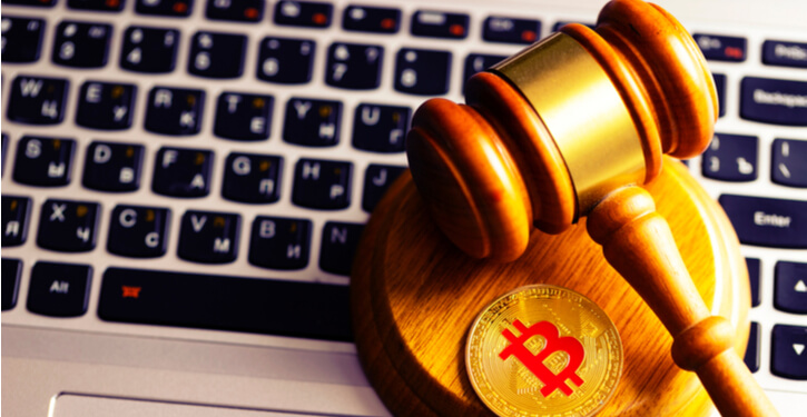 Image of a gavel with a bitcoin on it resting on a laptop
